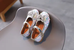 Detail of girls glitter Mary Jane shoes with rhinestone bow and sequin finish