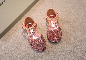 Detailansicht der pinkfarbenen Glitzer-Prinzessinnenschuhe mit Perlenriemen und Pailletten