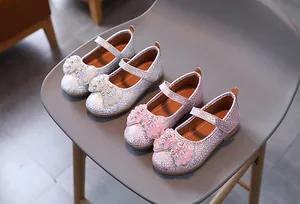 Detail of girls Mary Jane shoes featuring sparkly fish scale texture and pearl bows
