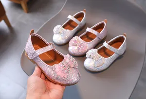 Detail of girls princess shoes with shiny sequins and crystal bow tie decorations