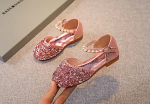 Detail eines rosa Mädchen-Prinzessinenschuhs mit glitzernden Pailletten und Perlenriemen