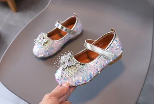 Detailed macro view of white sequined Mary Jane shoes for girls with glittery bow