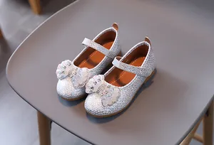 Detail of silver sequin Mary Jane shoe for girls with large rhinestone bow and pearl accents