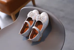 Detail of silver sequin Mary Jane shoes with glitter bows and sparkling bead accents