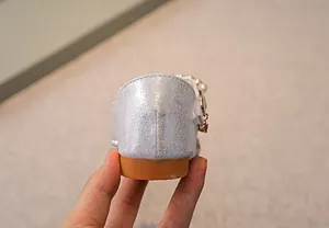 Detailansicht silberner Glitzer-Prinzessinenschuhe mit Perlenriemen und Gummisohle