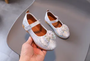 Close-up of glitter girl shoes with pearl and rhinestone bowknot decoration