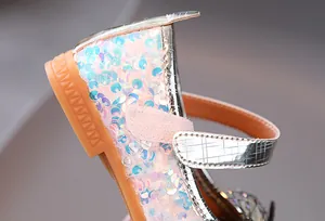 Macro detail of sparkly sequin texture and anti-slip rubber sole on girls princess shoes
