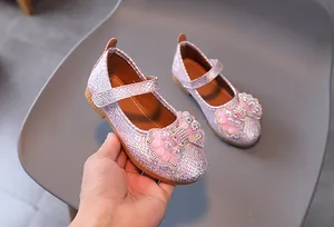 Detail of pink glitter girls' princess shoes featuring rhinestone mesh bow and buckled strap