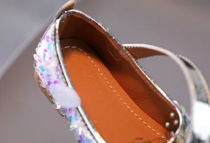 Detailed macro view of girls' glitter Mary Jane shoes with iridescent sequins and silver trim