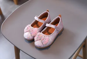 Detailed top view of pink sequin girls' Mary Janes with a decorative beaded bow