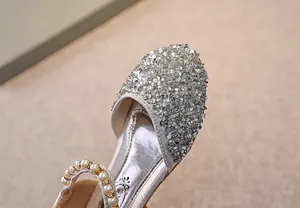 Detail von silbernen Prinzessinnenschuhen für Mädchen mit Glitzerpailletten und Perlen