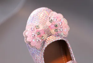 Close-up of pink sequin princess shoe with a sparkling rhinestone bow and pearl accents