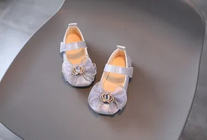 Detail von glitzernden Mädchen-Prinzessin-Schuhen mit Organza-Schleife und Krone