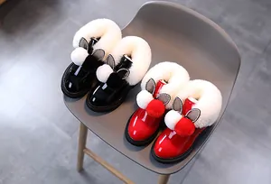Détail de bottes d'hiver brillantes pour filles avec bordure en fausse fourrure et oreilles de lapin