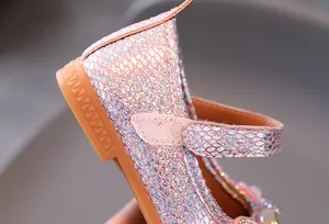 Detailed macro view of girls' princess shoes featuring shimmering scales and velcro strap