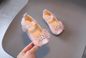 Detail von rosa Mädchen Mary Janes mit Strasskrone und Schleife aus Netzmaterial