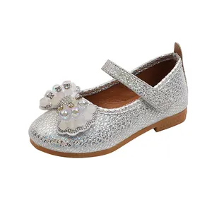 Detail of silver sequined Mary Jane shoes featuring a bow with faux pearls and rhinestones