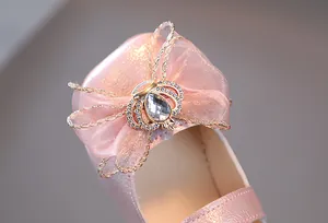 Detail von rosa Perlglanz-Mädchenschuh mit Organza-Schleife und Kronen-Strass