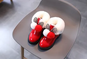 Détail de bottes d'hiver en cuir verni rouge avec fourrure pelucheuse et oreilles de lapin