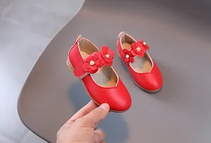 Detail von roten Mary Jane Schuhen für Mädchen mit Lederblumen und Perlenakzenten