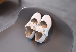 Detail von weißen Mädchen Mary Jane Schuhen mit 3D-Blumen und Perlenverzierung