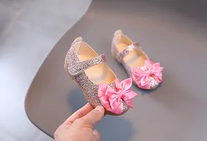 Nahaufnahme der rosa Pailletten-Mary Janes für Mädchen mit mehrlagiger Satinschleife