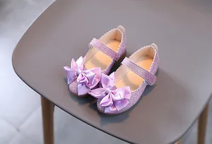 Details von lavendelfarbenen Glitzerschuhen für Mädchen mit Satinschleife und Wellenrand