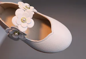 Detail von weißen Mary-Jane-Schuhen mit strukturiertem Leder und 3D-Blumenperlen