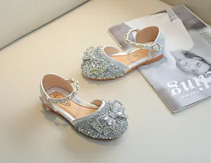 Détail de chaussures Mary Jane argentées à paillettes avec nœud strass et bride perle
