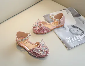 Détail de la chaussure de princesse rose avec paillettes et un grand nœud en strass brillant