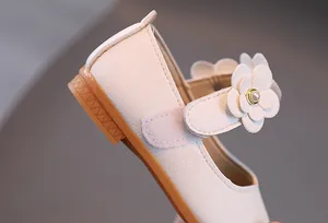 Detail der Mary Jane Kinderschuhe mit Litschi-Lederstruktur und 3D-Blumendekoration