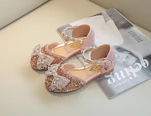 Détail de chaussures Mary Jane roses à paillettes avec nœud strass et bride en perles