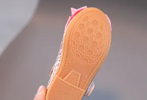 Makroaufnahme der rutschfesten Gummisohle und des rosa Glitzerstoffs bei Mädchen-Halbschuhen