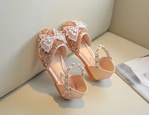Détail de chaussure princesse à paillettes rose doré avec nœud en strass et perles