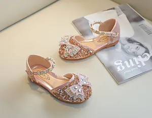 Détail de sandales roses pailletées pour filles avec nœud en strass et brides en perles