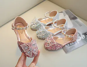 Détail de chaussures Mary Jane roses avec paillettes, nœud et bride en strass et perles