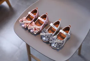 Détail de chaussures de princesse à paillettes pour filles en rose et argent avec nœud
