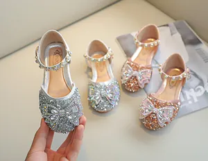 Détail de chaussures pailletées montrant les sequins, le nœud strassé et la bride de perles
