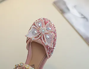 Détail de chaussures de princesse roses à paillettes avec un nœud papillon en strass brillant