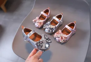 Gros plan détaillé de chaussures princesse pour filles avec nœuds à paillettes et strass