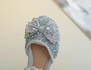Détail de chaussures princesse argentées pour filles avec paillettes et nœud brillant