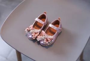 Détail de chaussures Mary Jane roses avec nœuds à paillettes et strass brillants