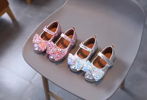 Dettaglio di scarpe Mary Jane glitterate per bambine con fiocchi di paillettes rosa