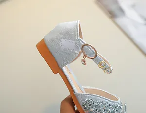 Détail de chaussure Mary Jane à paillettes argentées avec boucle en strass
