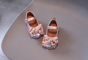 Gros plan détaillé sur chaussure Mary Jane rose pailletée avec nœud en strass brillant