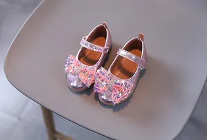 Vista dettagliata di ballerine Mary Jane rosa con paillettes e fiocco colorato per bambine