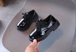 Detail of black faux leather boy's dress shoes with snakeskin texture and anti-slip sole