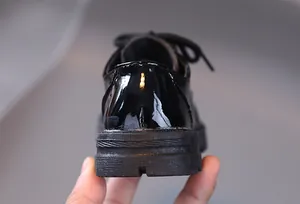 Detailed macro shot of the thickened rubber heel and glossy patent leather of the boys shoe