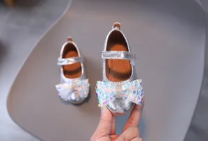 Dettaglio di scarpe da principessa argento per bambine con fiocco di paillettes