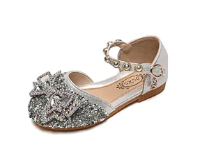 Détail de chaussures de princesse argentées avec nœud en cristal et bride en strass